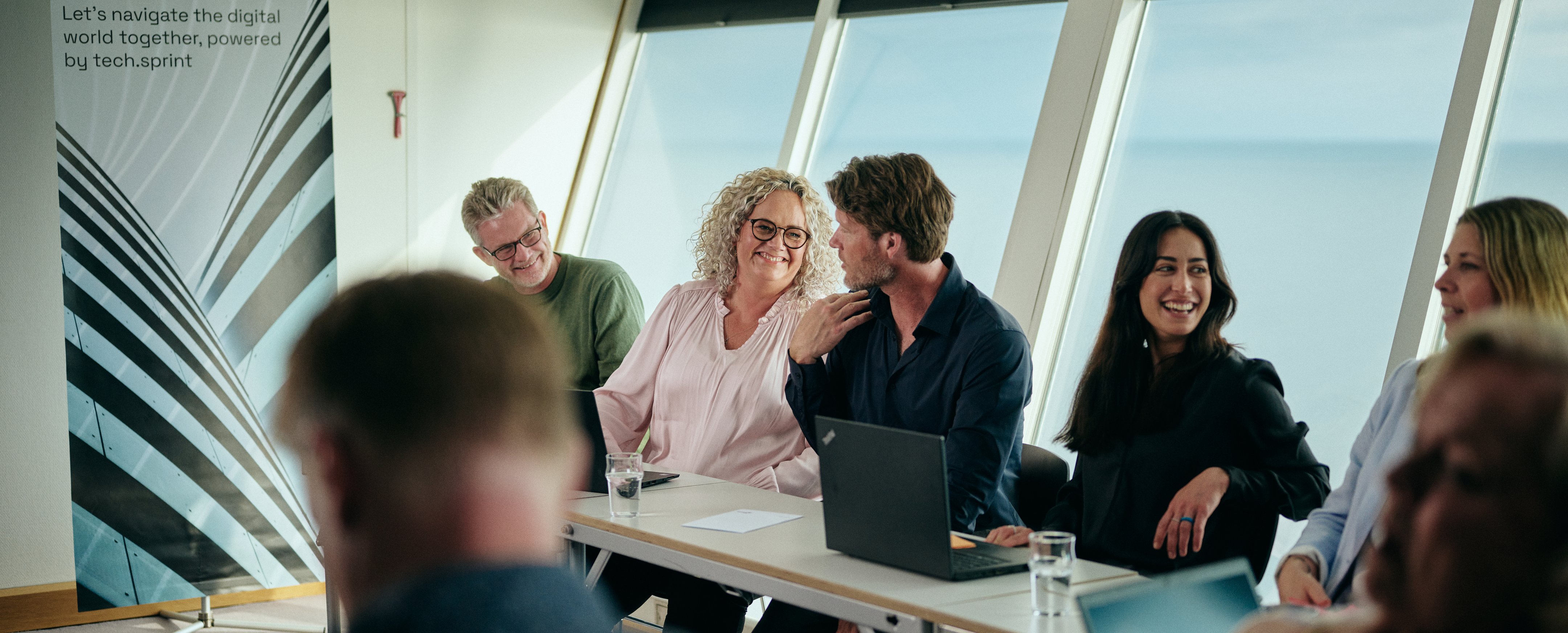 Møte med PC-er ved vannutsikt, banner: "Welcome on board..."
