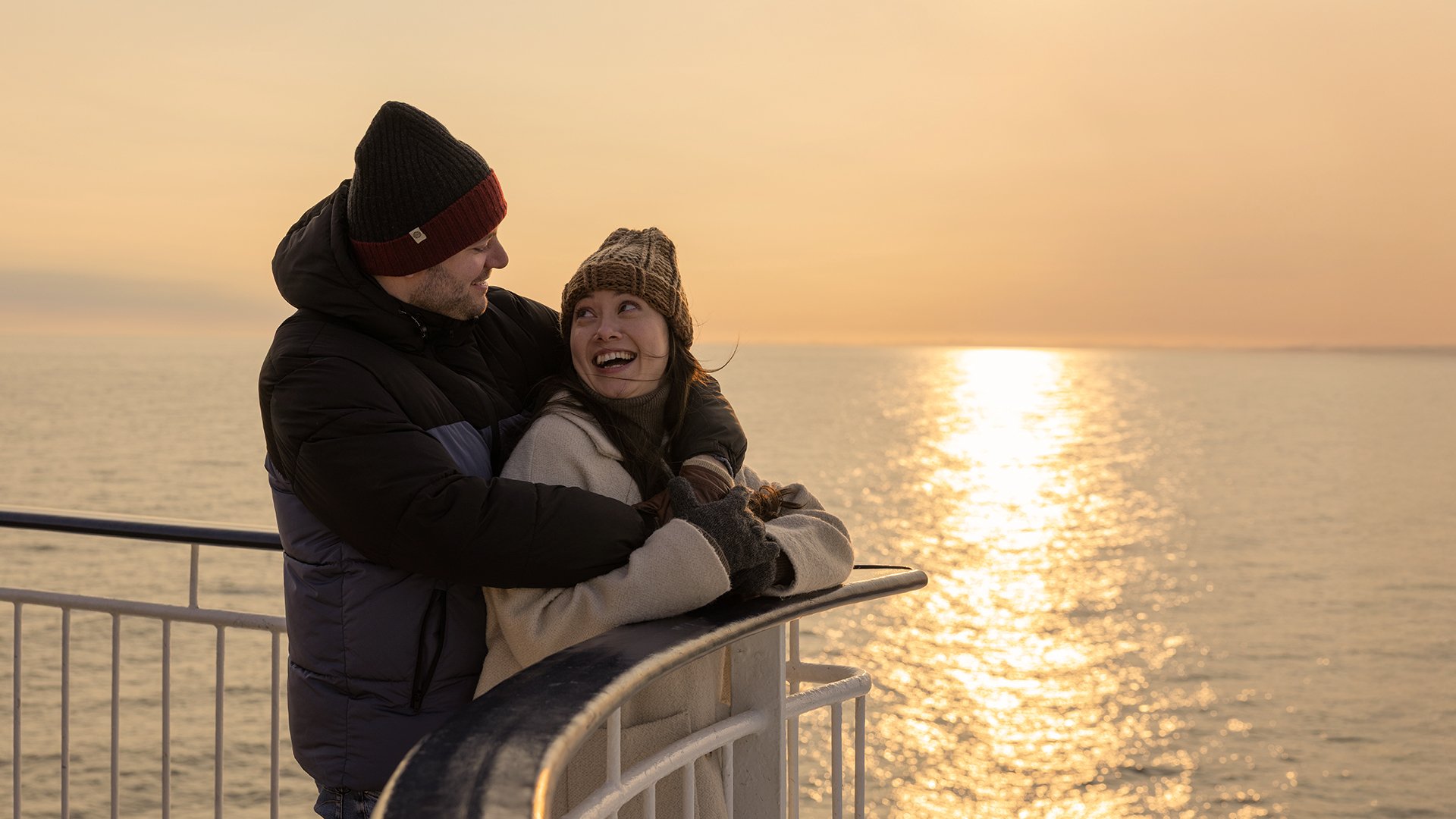 par ute på dekk i solnedgang