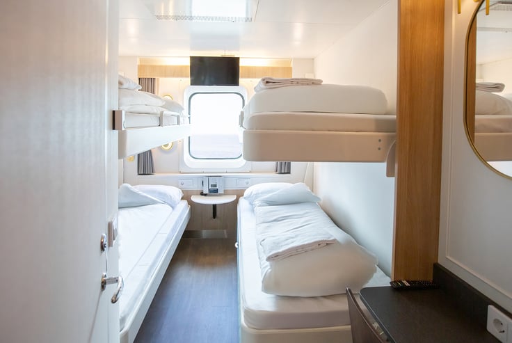 Kjæledyrvennlig lugar med to sett køyesenger og et vindu.