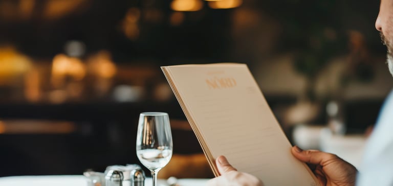 Person som holder meny på NÓRD restaurant.