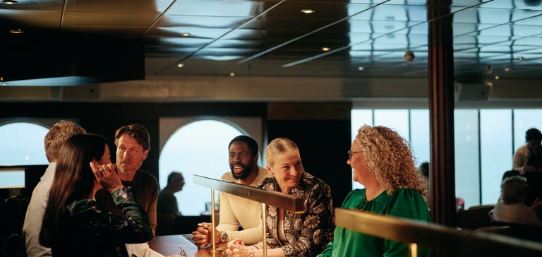 Gruppe mennesker som sitter ved en bardisk i en restaurant.