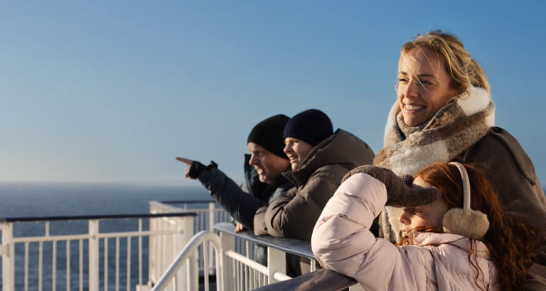 Familie ser utover havet fra dekk