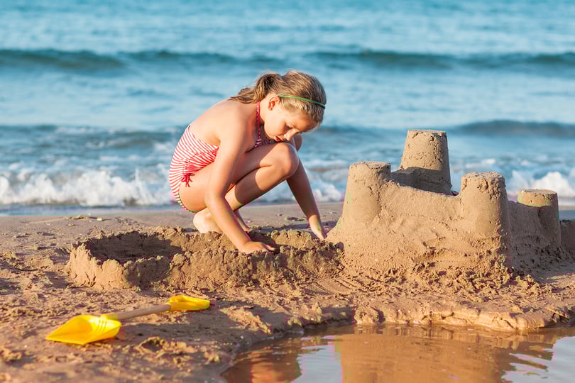 Jente bygger sandslott